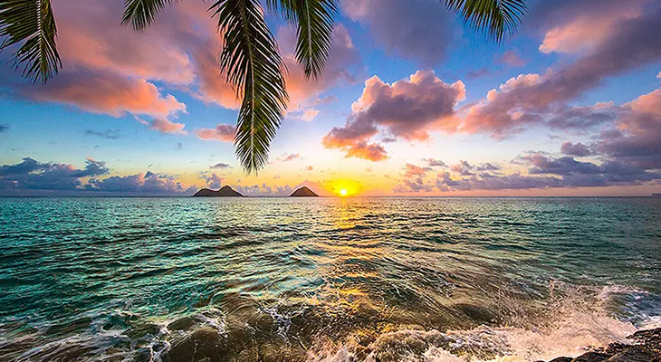 Best island vacations in 2025 – turquoise lagoon, white sand beach, and palm trees at sunset