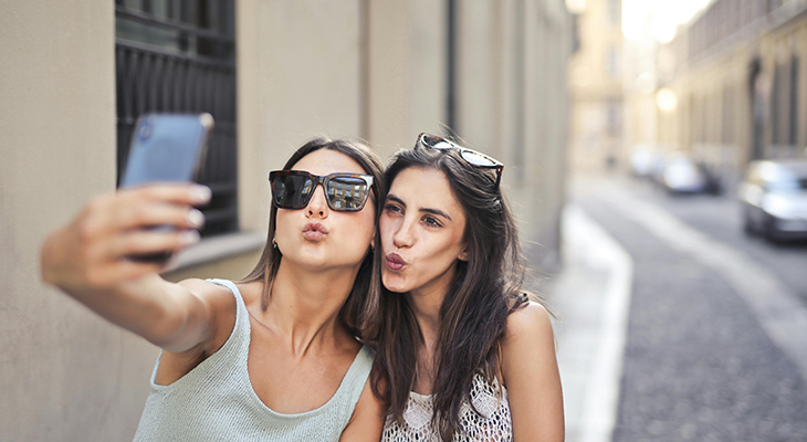 Two sisters traveling solo watching sunset over city skyline