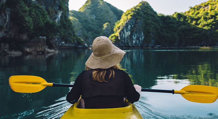 Best places to solo travel as a woman—illustration of a woman traveler overlooking Lisbon rooftops and Kyoto temple